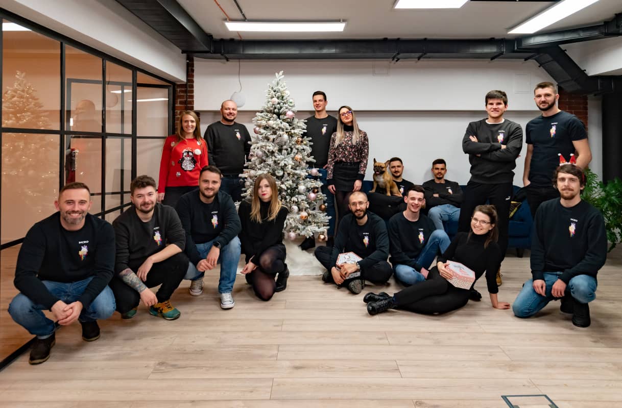 Group of people sitting next to a Christmas tree Group of people sitting next to a Christmas tree